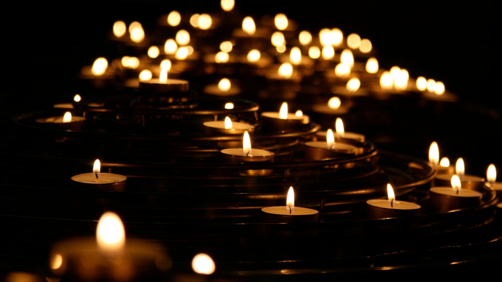 Warm, glowing candles in soft bokeh, tasteful and calm.