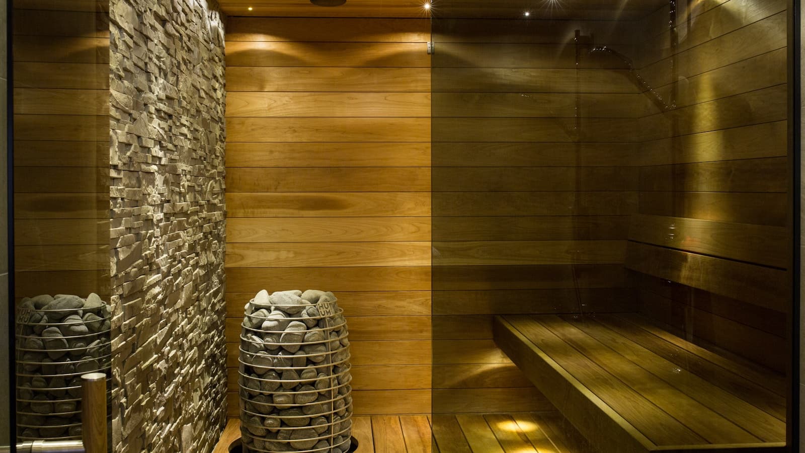 A minimalist wooden sauna bench area with concrete wall accents.