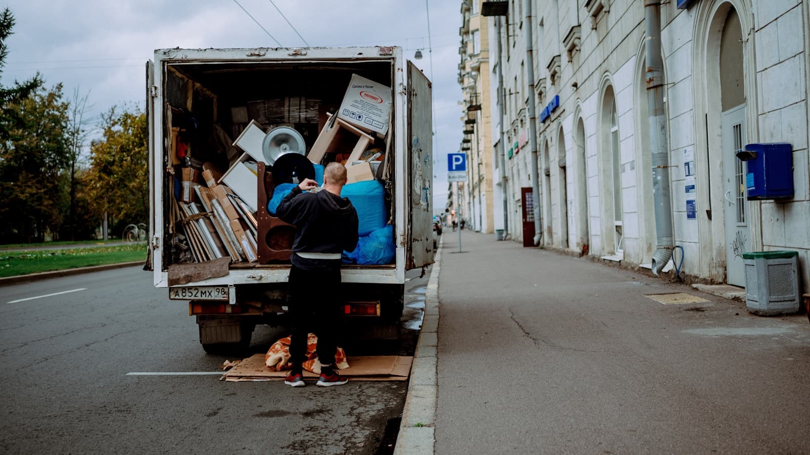 A man unloading furniture from the back of a moving truck.