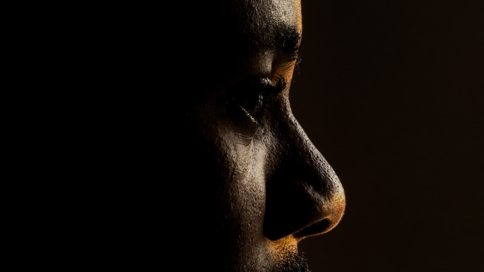 A dramatic, tasteful profile portrait of a man in moody side lighting.