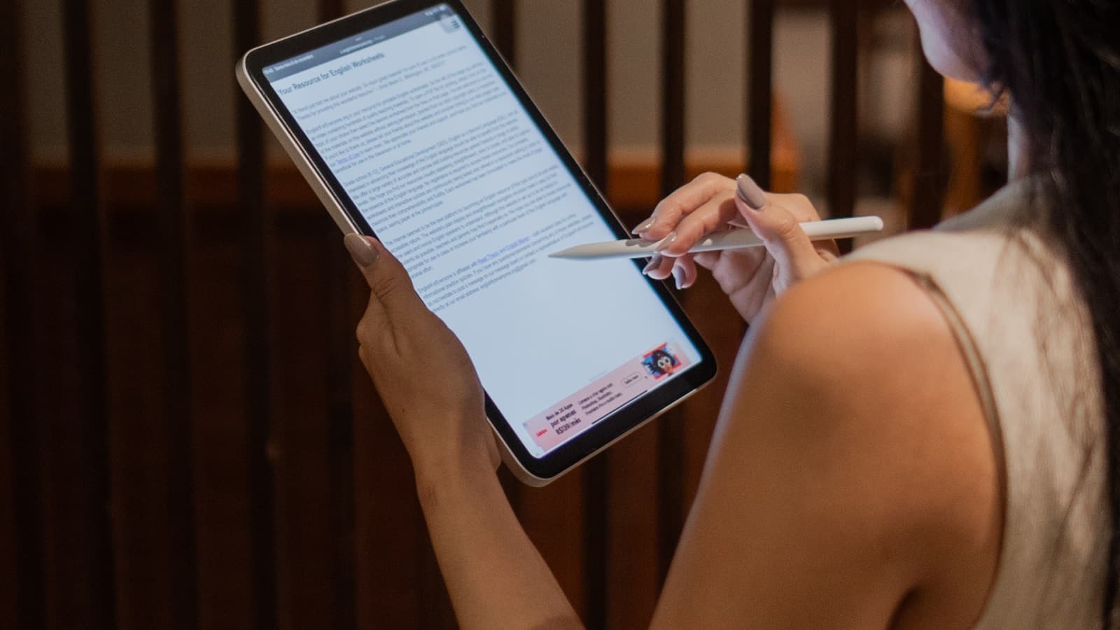 A woman holding and using a tablet device in her hands.