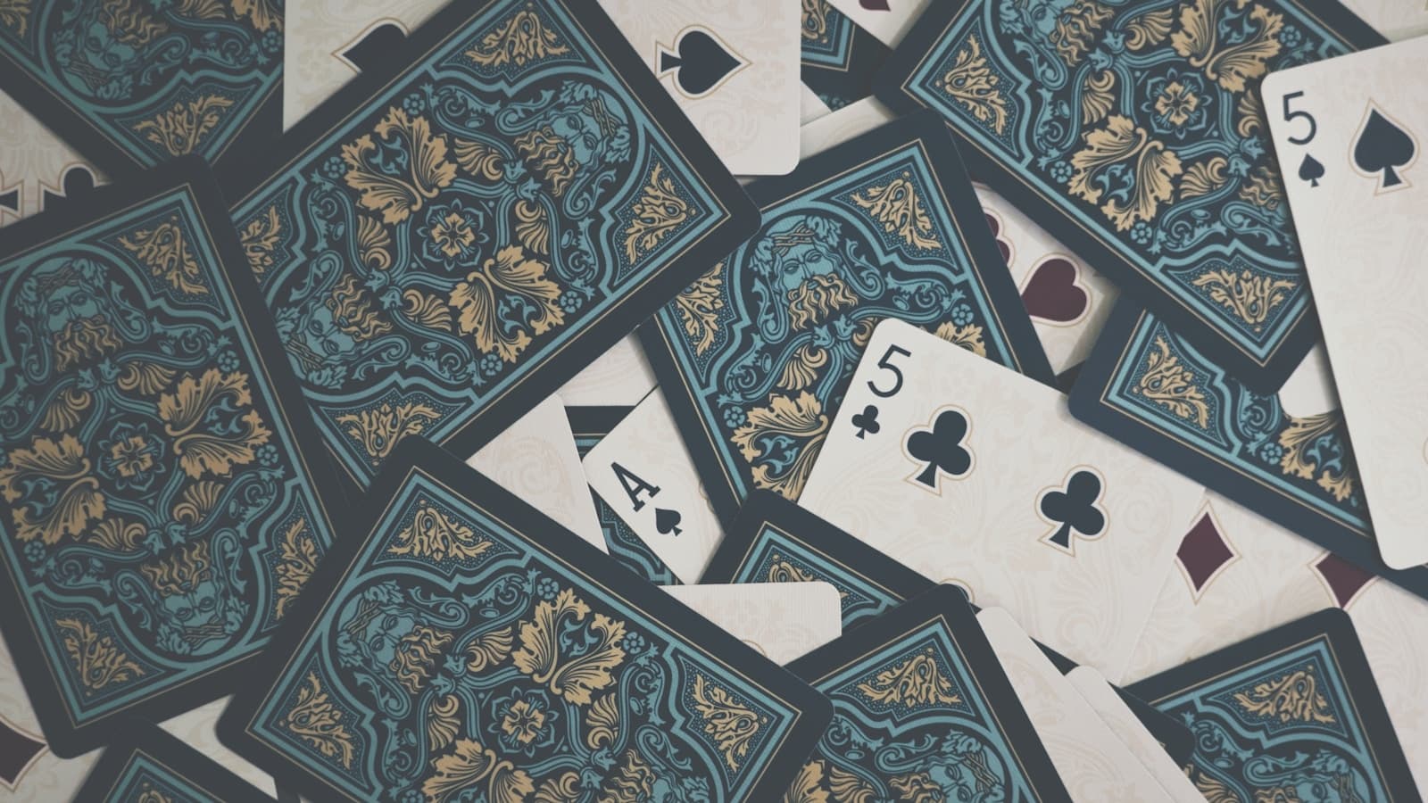 A spread pile of ornate-backed playing cards with a few face-up.