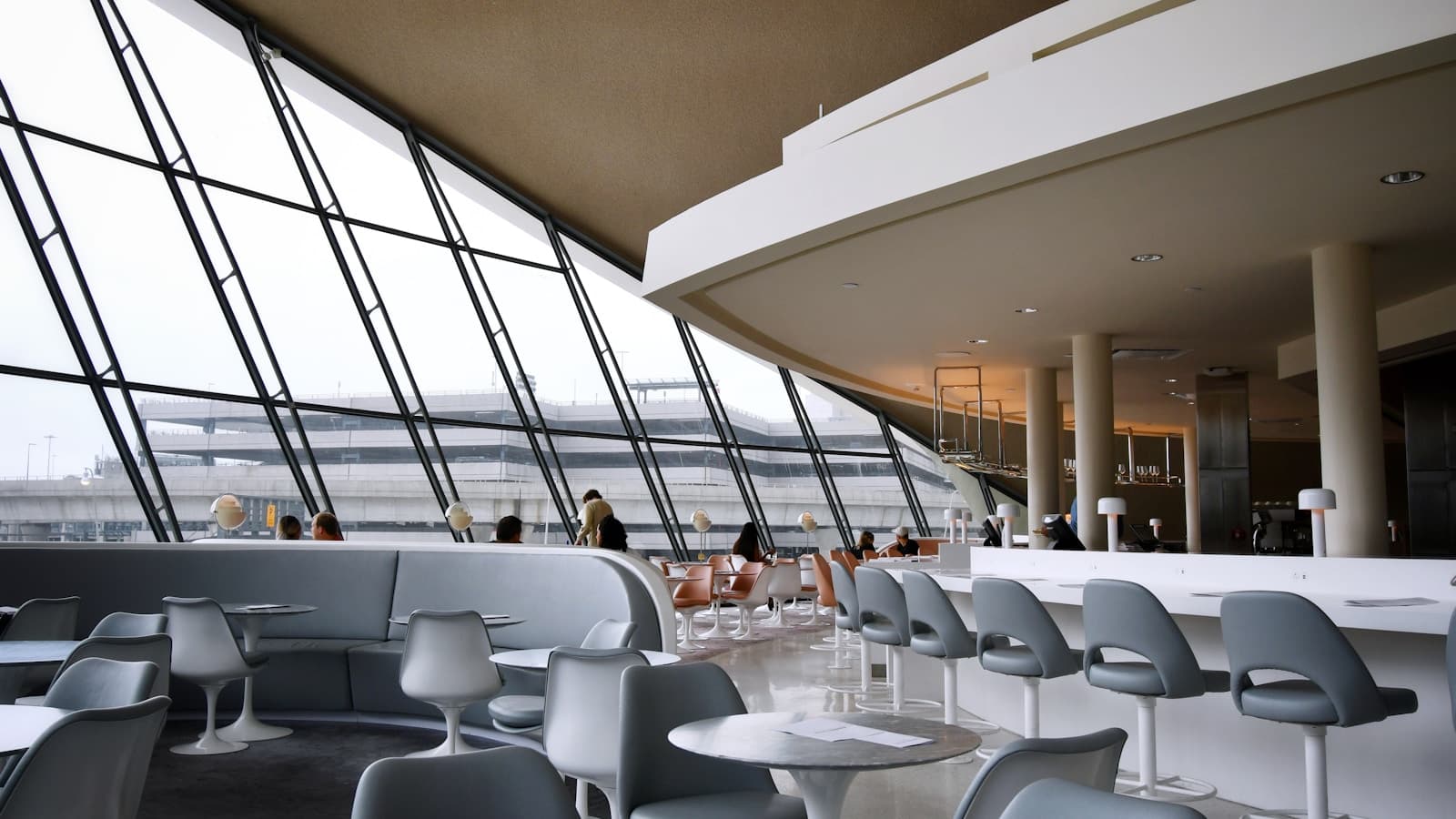 A mid-century modern airport lounge interior with sofas and chairs.