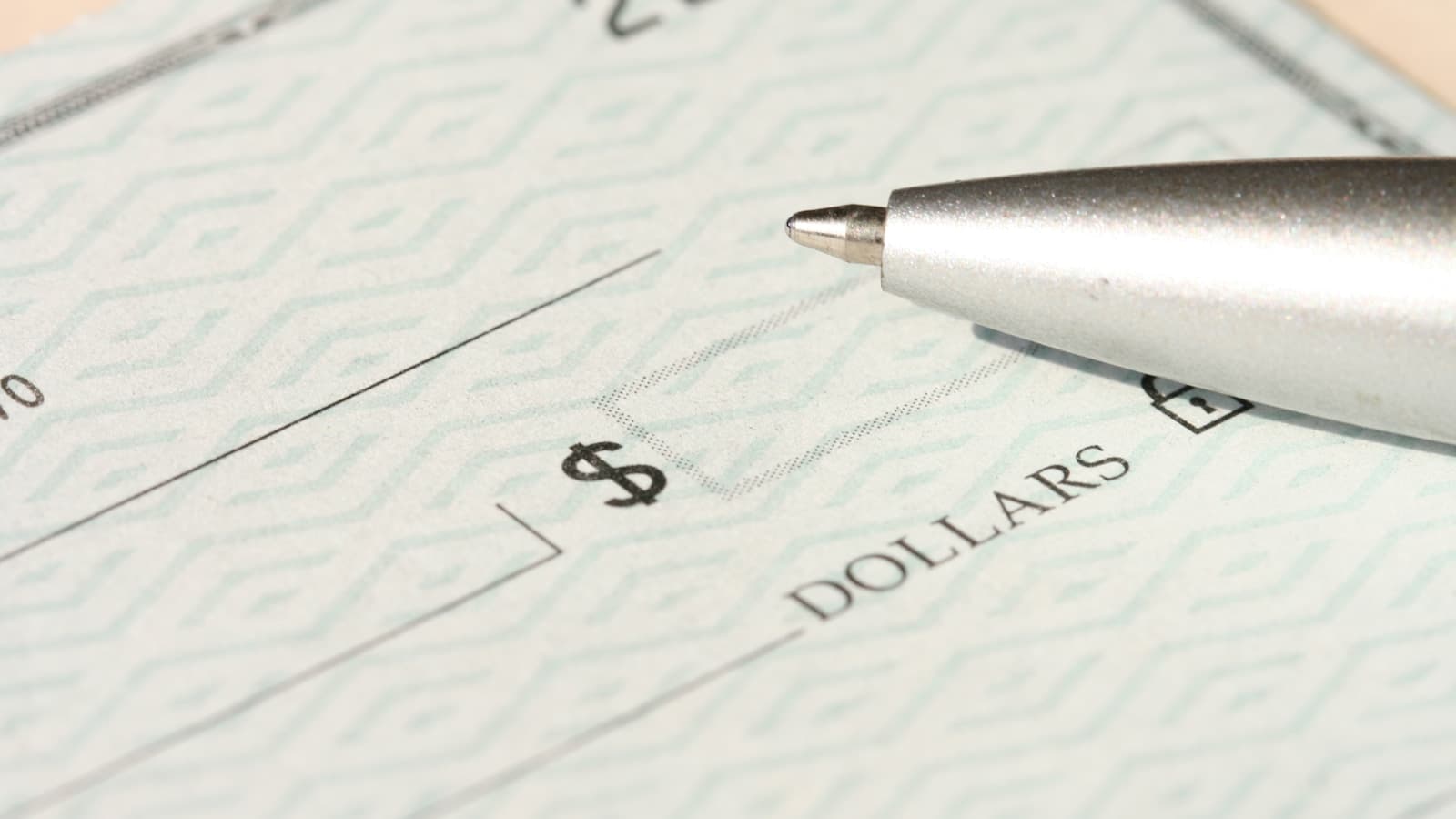 A matching close-up of a blank check and pen, slightly different angle.