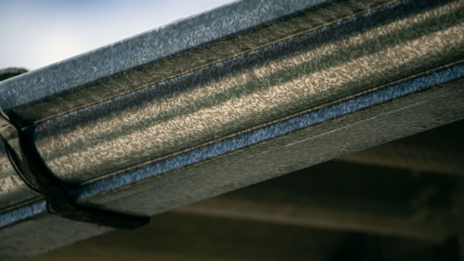 Close-up of a clean metal gutter under a roofline.