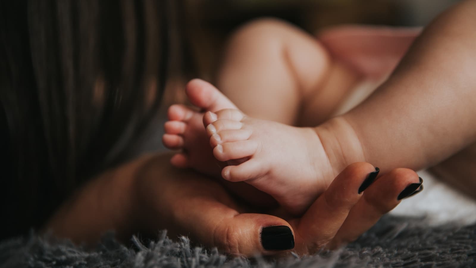 A close, warm portrait of a caregiver holding a smiling toddler.