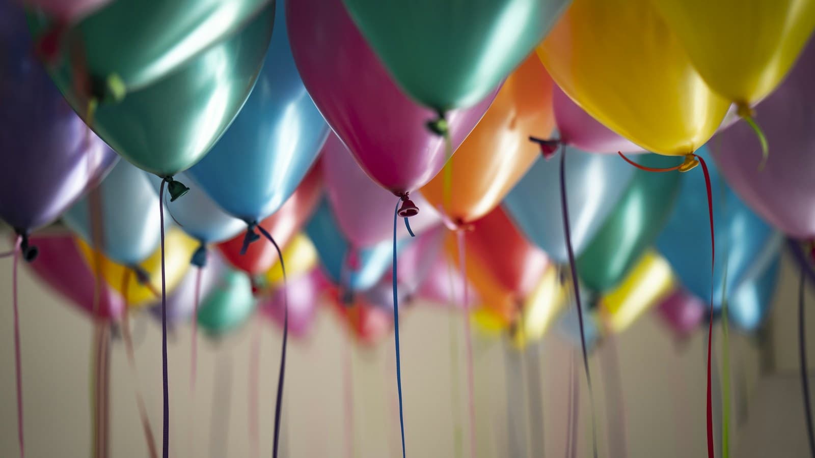 A close-up of colorful balloons at a birthday party, softly out of focus.