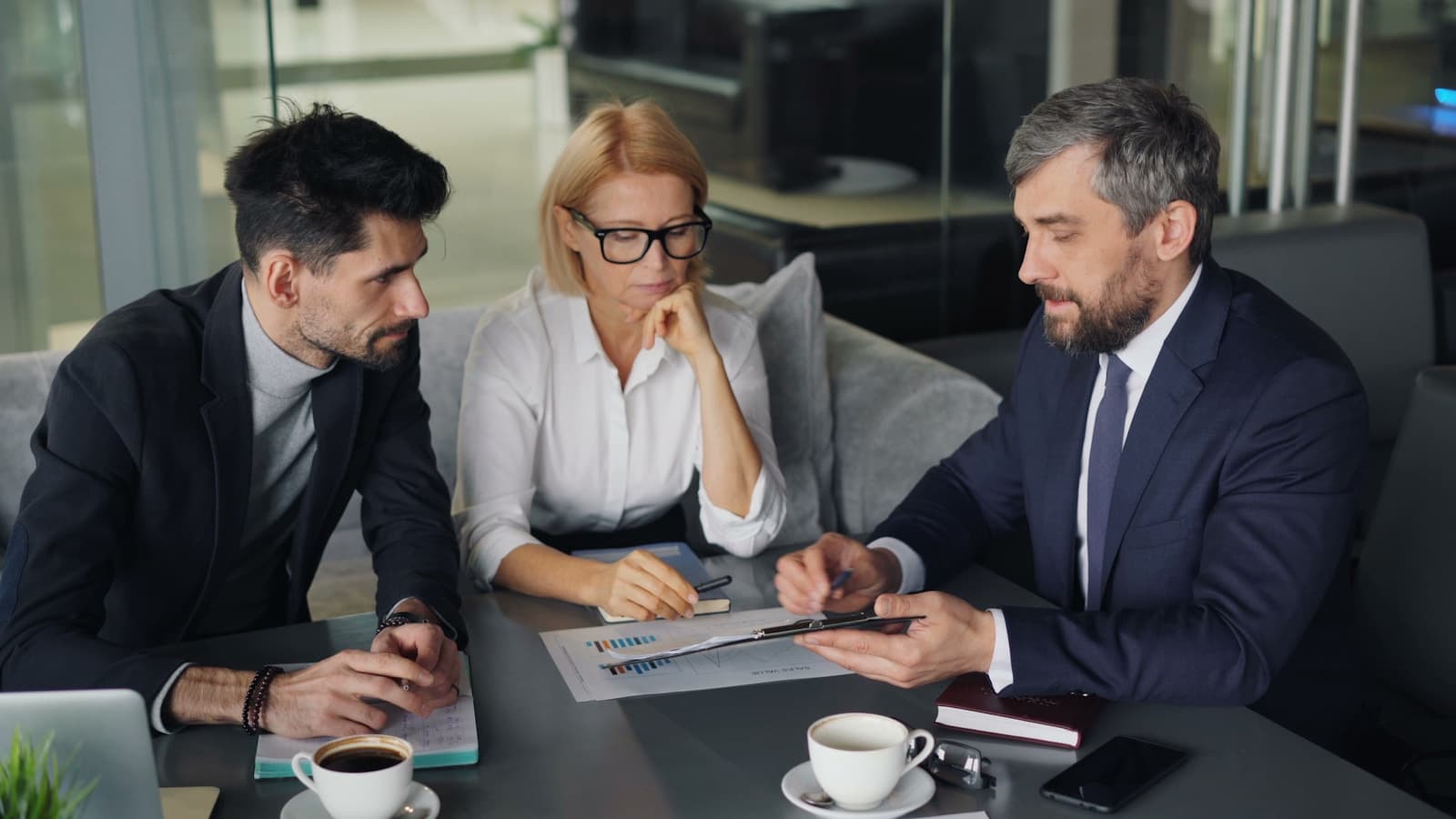 Multiple people gathered around a table in a serious discussion.