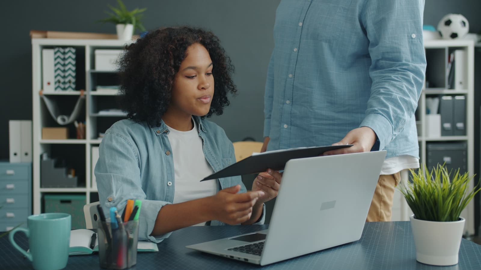 Two colleagues reviewing multiple documents together at a desk.