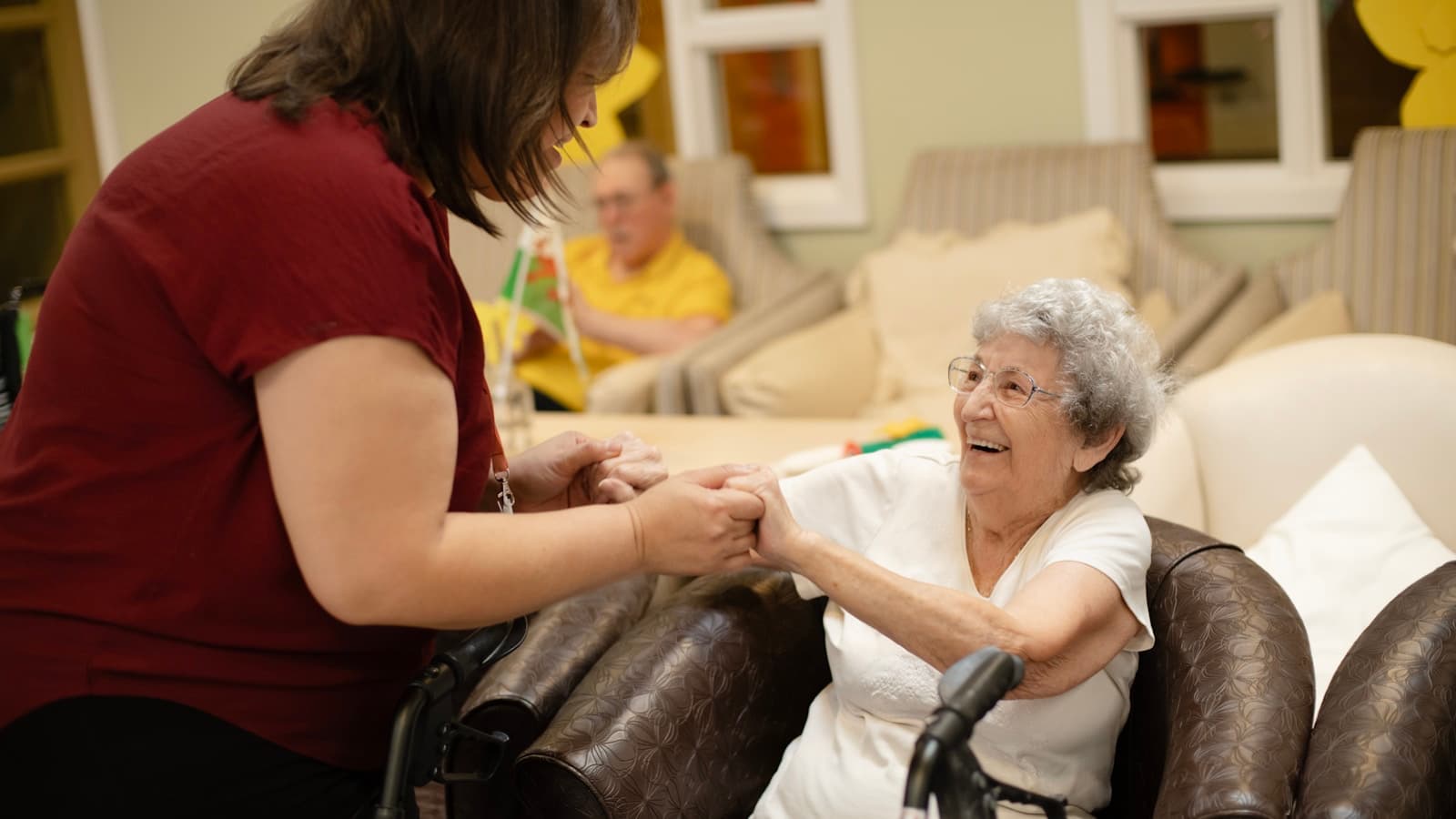 A caregiver assisting an elderly woman with her walker at home.