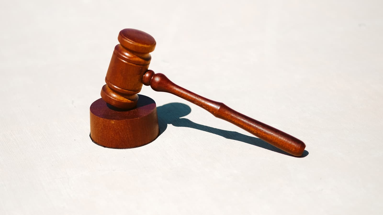 A single wooden judge's gavel on a plain white surface, with no people, text, or logos visible.