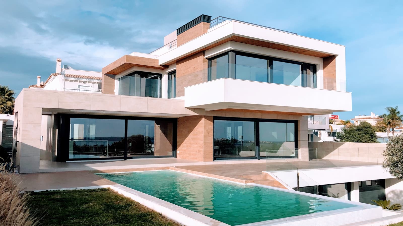 A modern white and brown house exterior, daytime, no visible address or signage.
