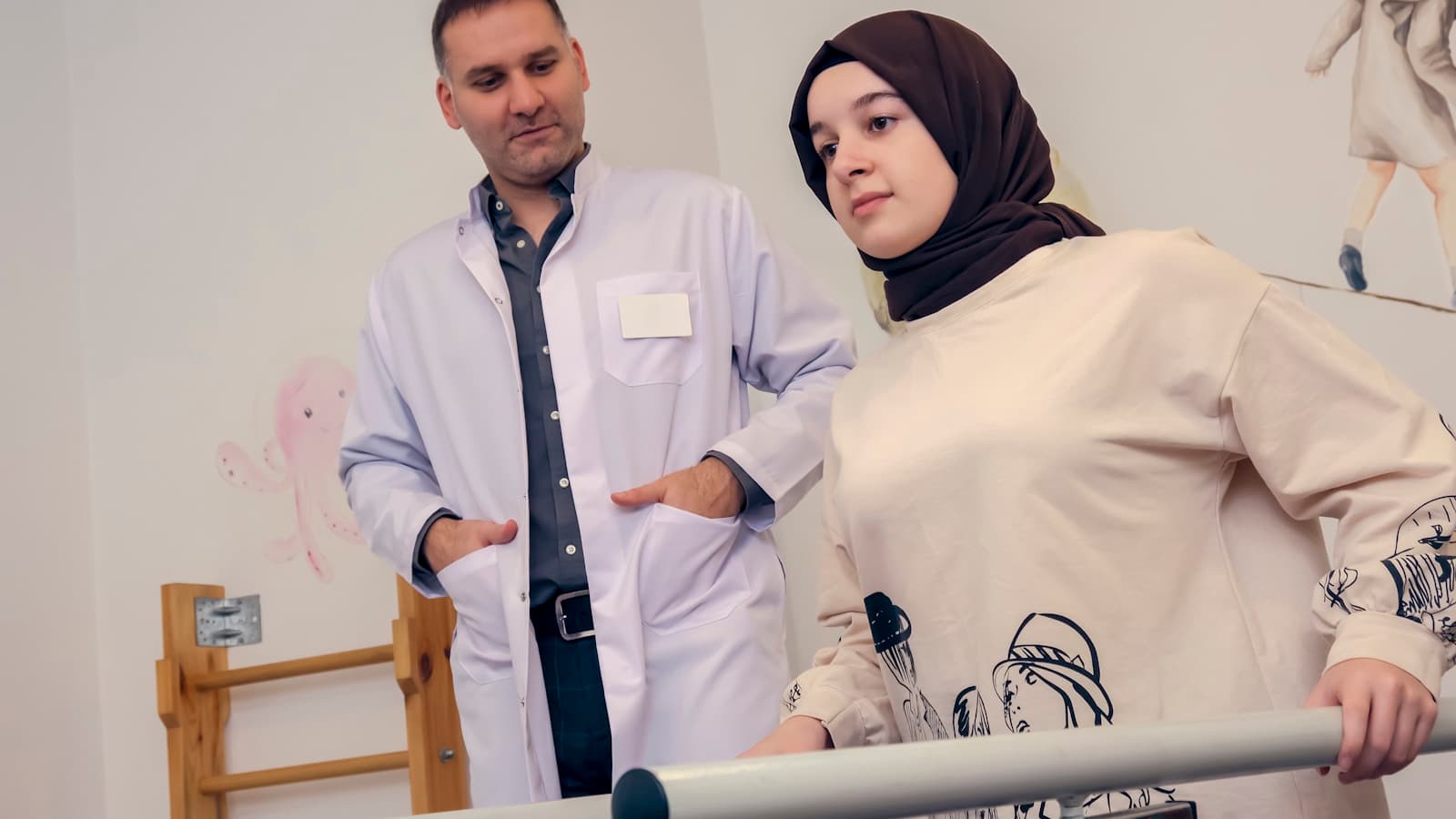 A clinician assisting a patient with gait training between parallel support bars.
