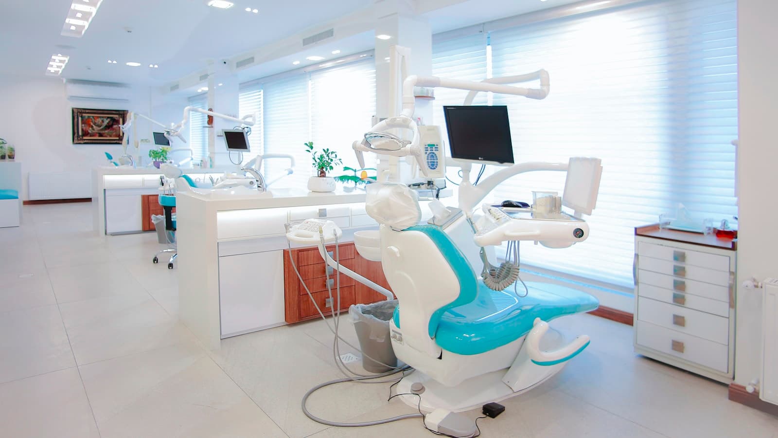 A spacious, bright multi-chair modern dental clinic interior.