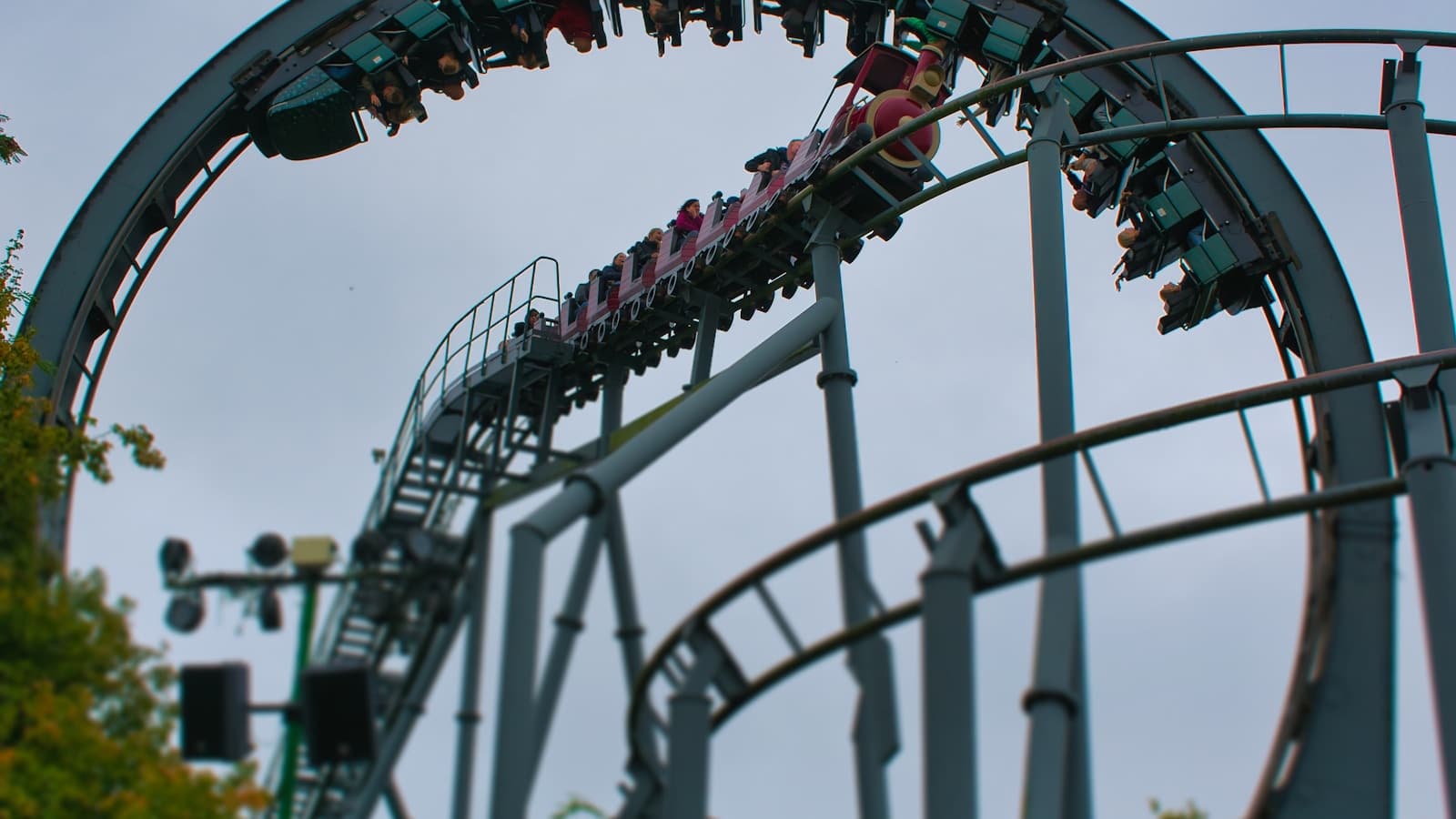 A roller coaster train full of riders going through a loop.