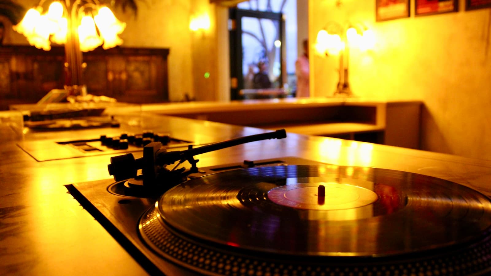 A turntable with a vinyl record on a wooden counter, modern styling.