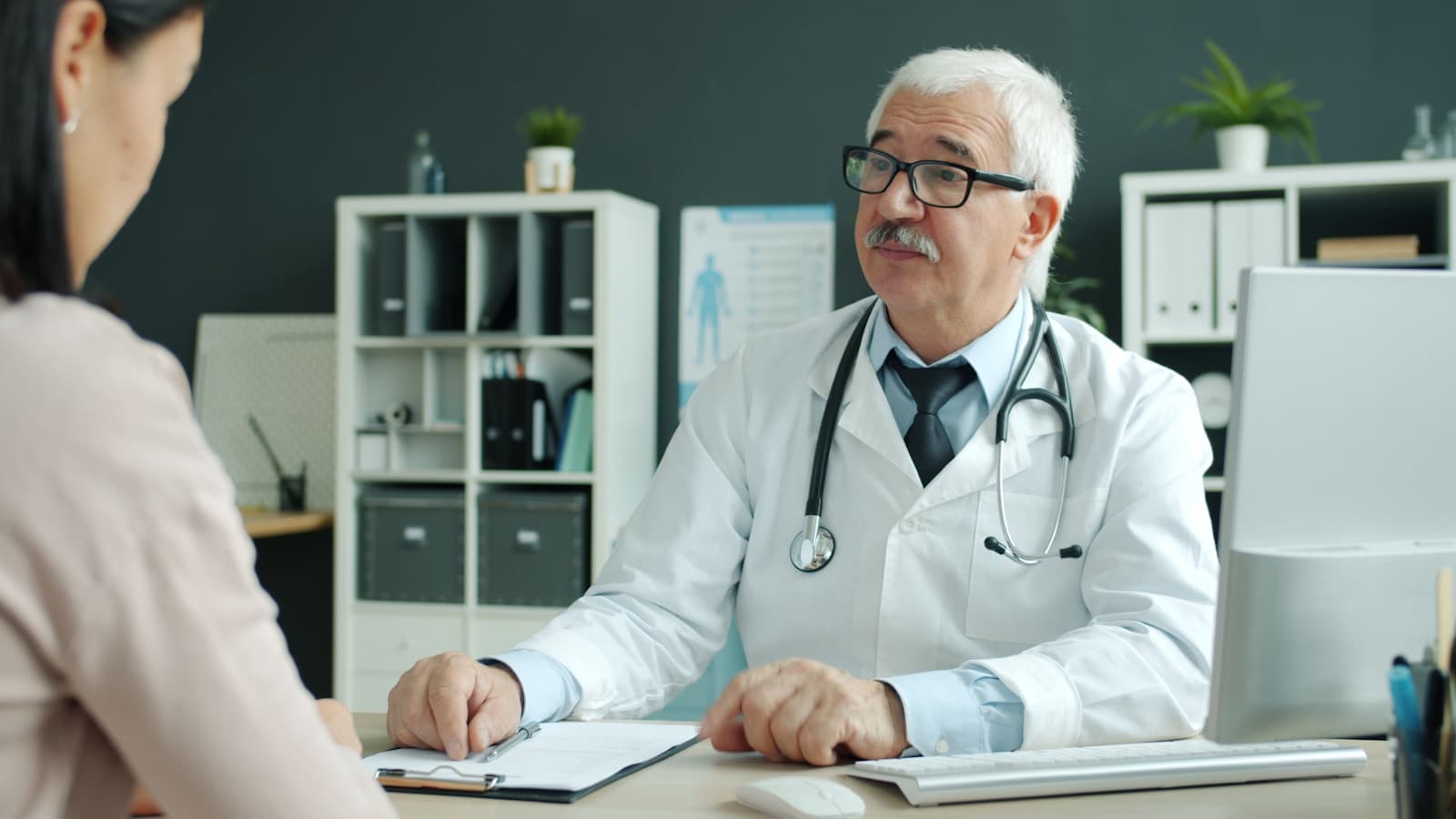 A doctor consulting with a patient in a modern, calm office.