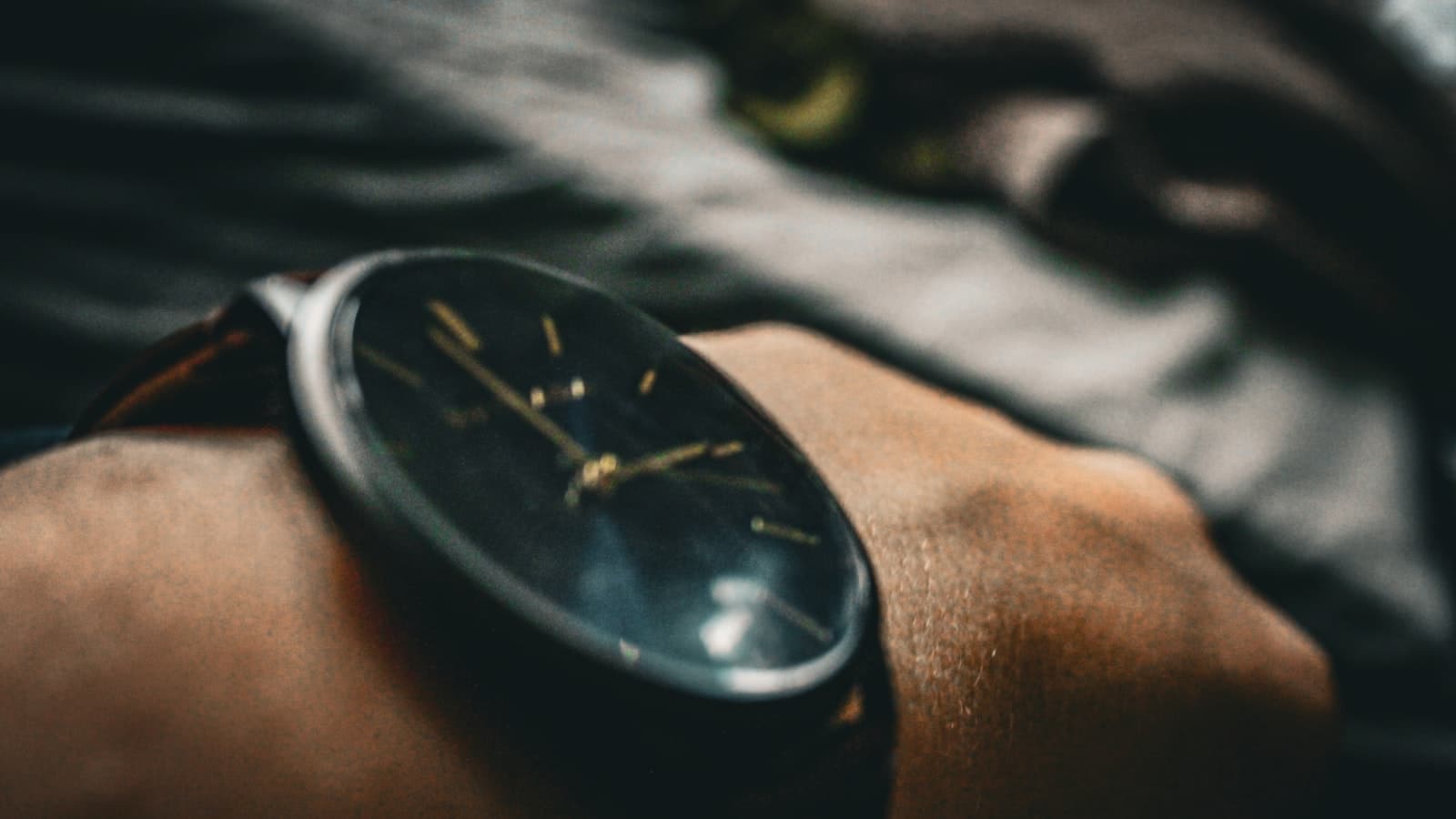 Close-up of a plain dark wristwatch on a person's wrist with no visible brand markings, face, or text.
