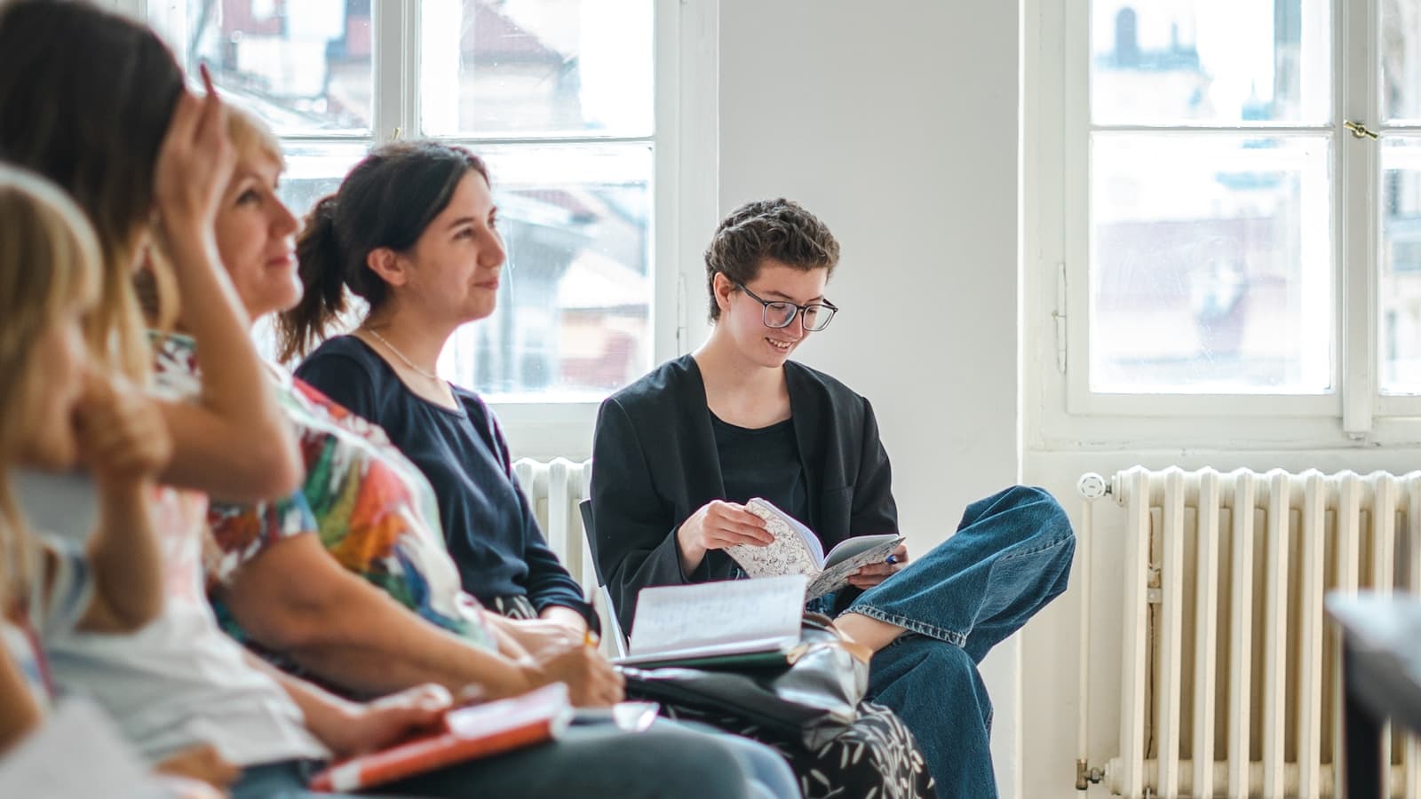 A small group sitting together in a bright room, supportive group-session feel.