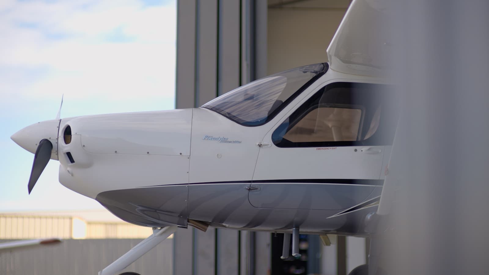 Close-up of a small plane's nose tucked inside an open hangar.
