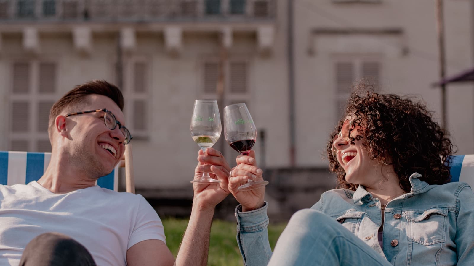 A man and woman toasting with wine glasses.