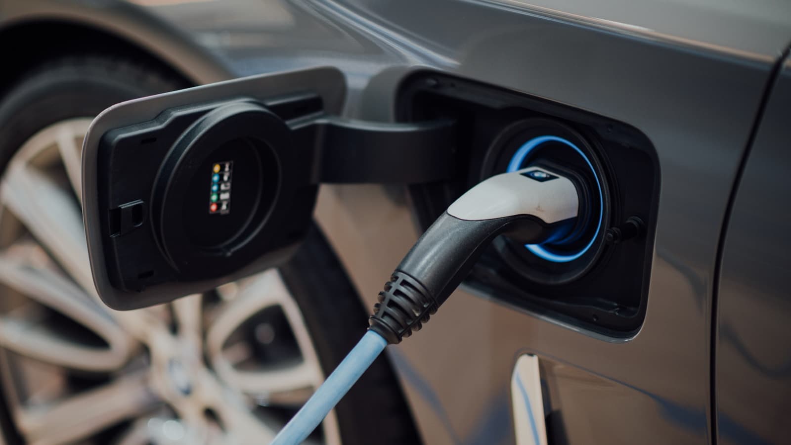 Close-up of a charging cable plugged into an electric car's charging port.