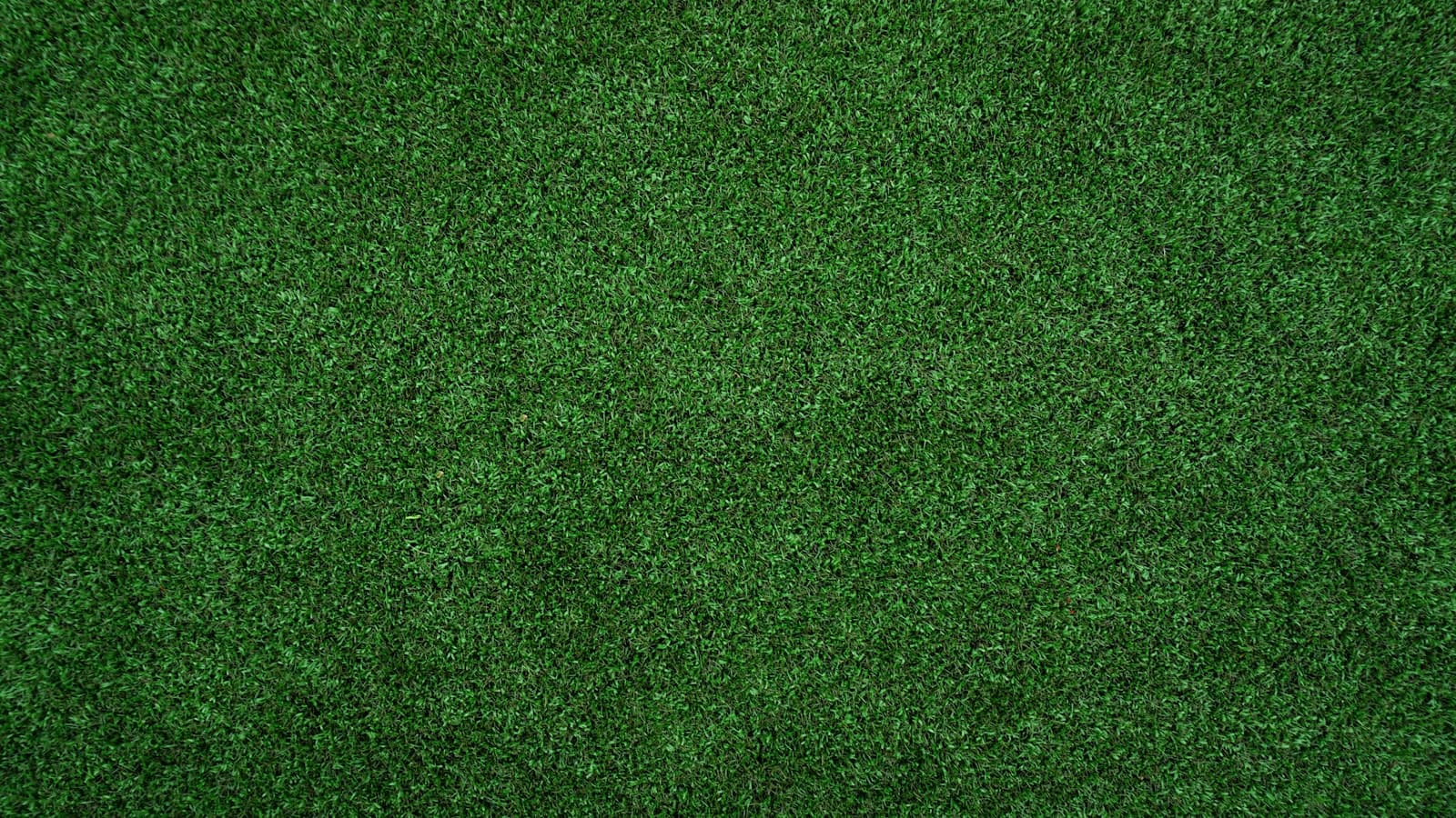 A top-down close-up of dense green artificial turf texture, with no people, text, or logos visible.