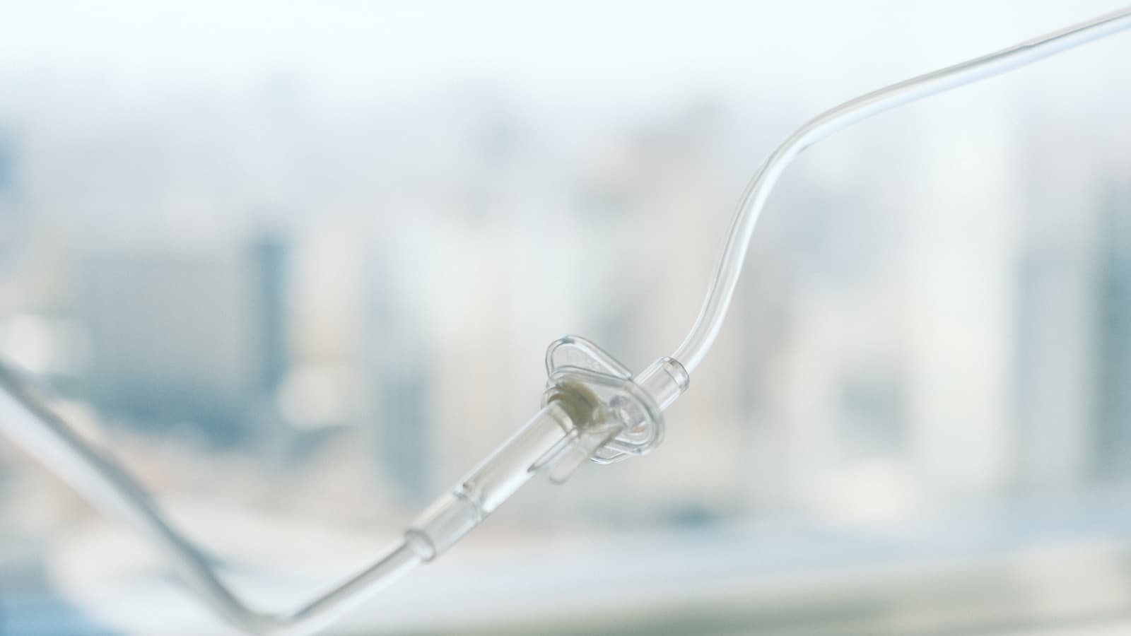 An abstract close-up of IV tubing against a softly blurred clinical background.