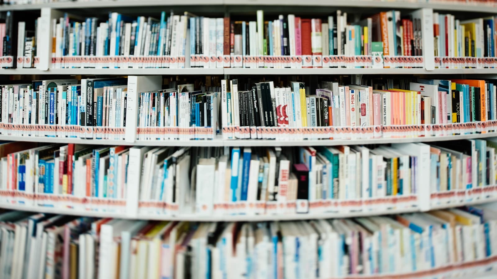 Curved library shelves densely packed with colorful books, individual titles not legible, no people visible.