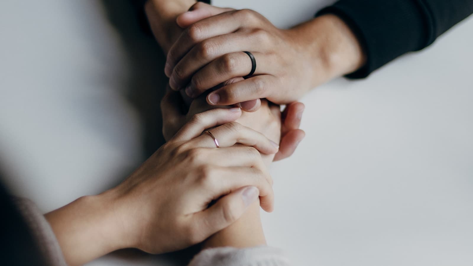 Close-up of a couple's clasped hands at a table.