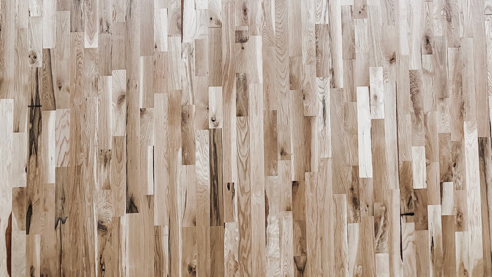 A close-up overhead shot of clean, new light-toned wood plank flooring; no people or text.
