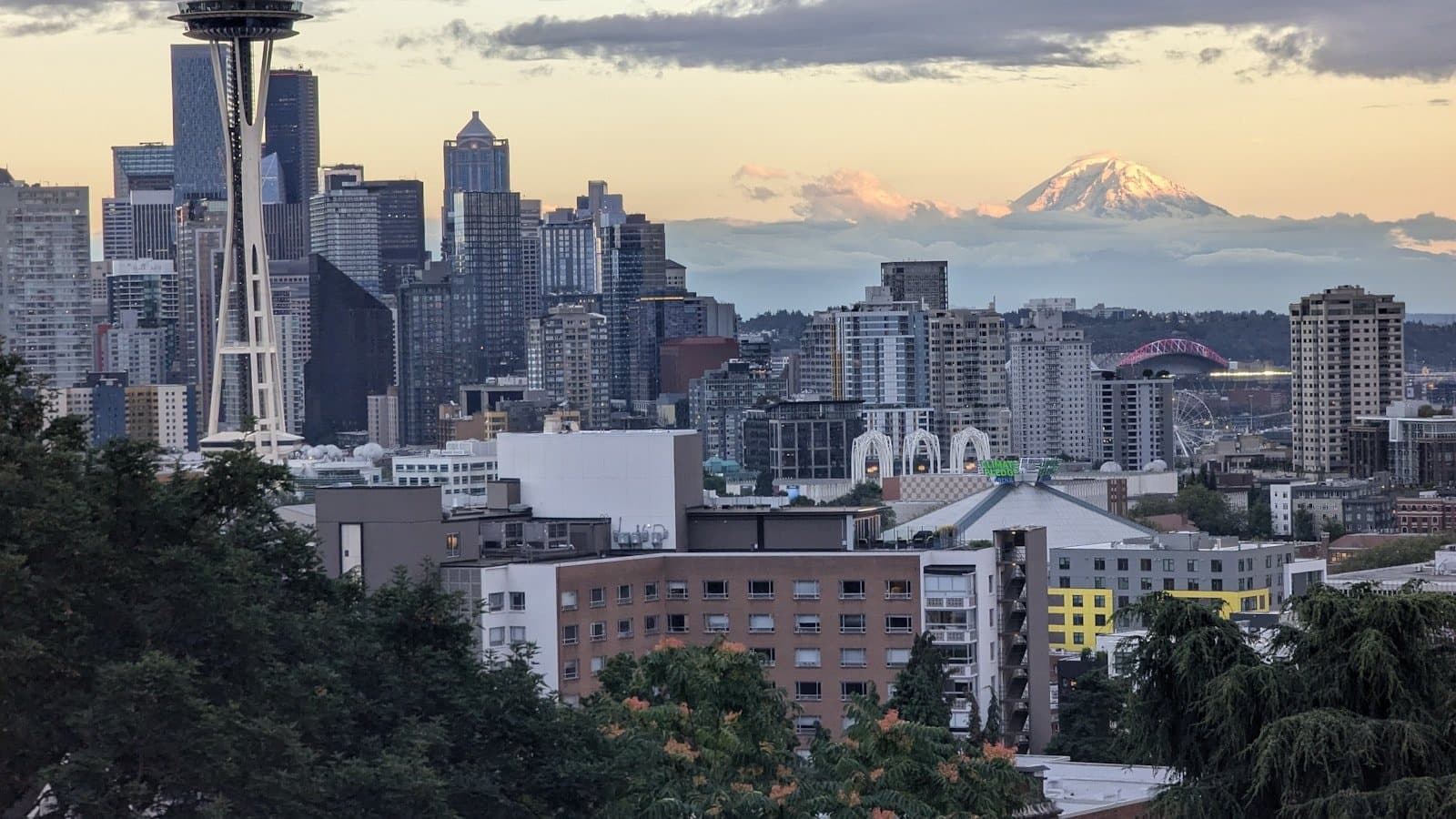 The Seattle skyline at dusk from Kerry Park, with the Space Needle in the foreground and snow-capped Mount Rainier visible in the distance.